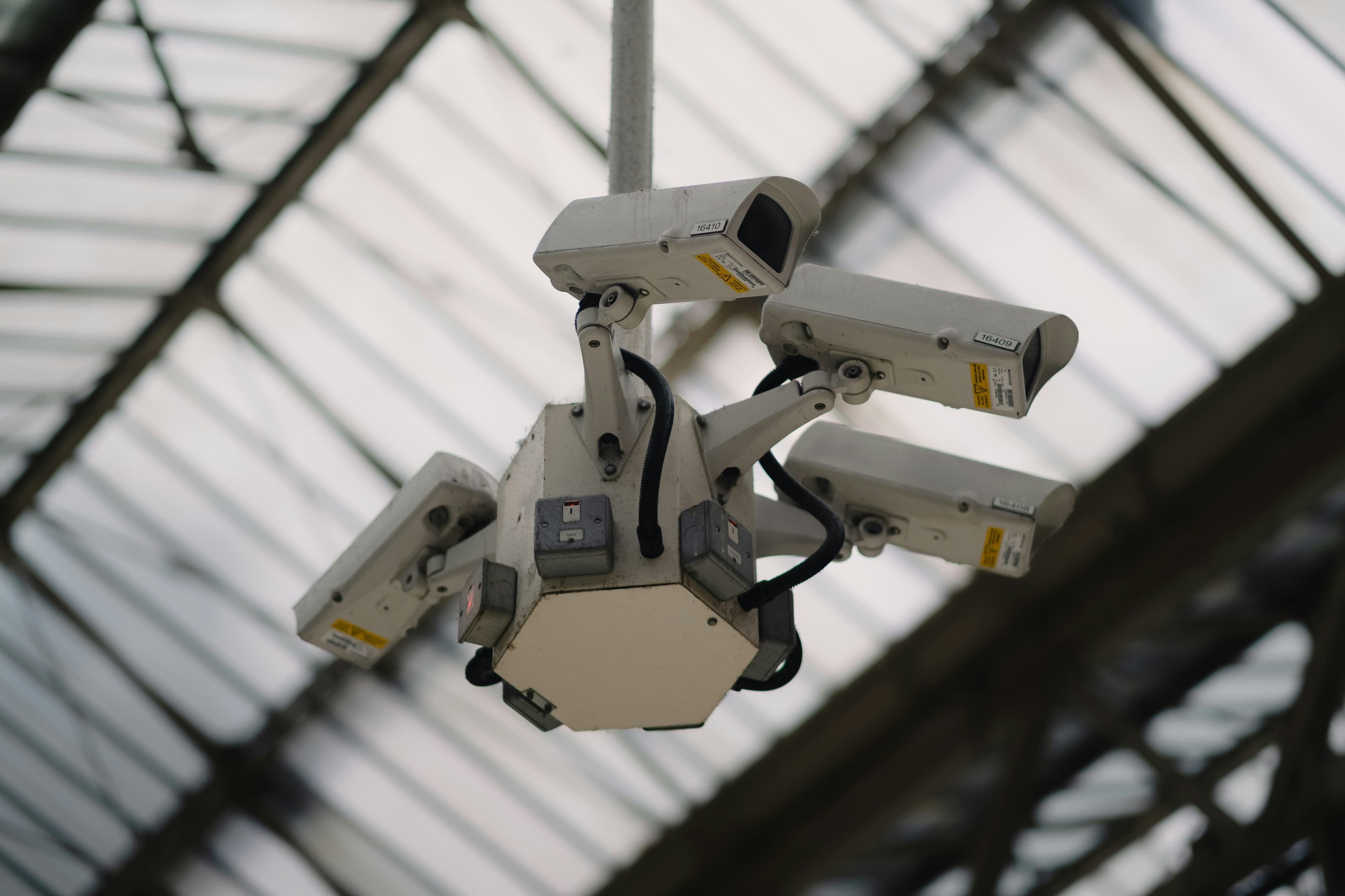 Multi-camera CCTV surveillance cluster mounted under an industrial roof